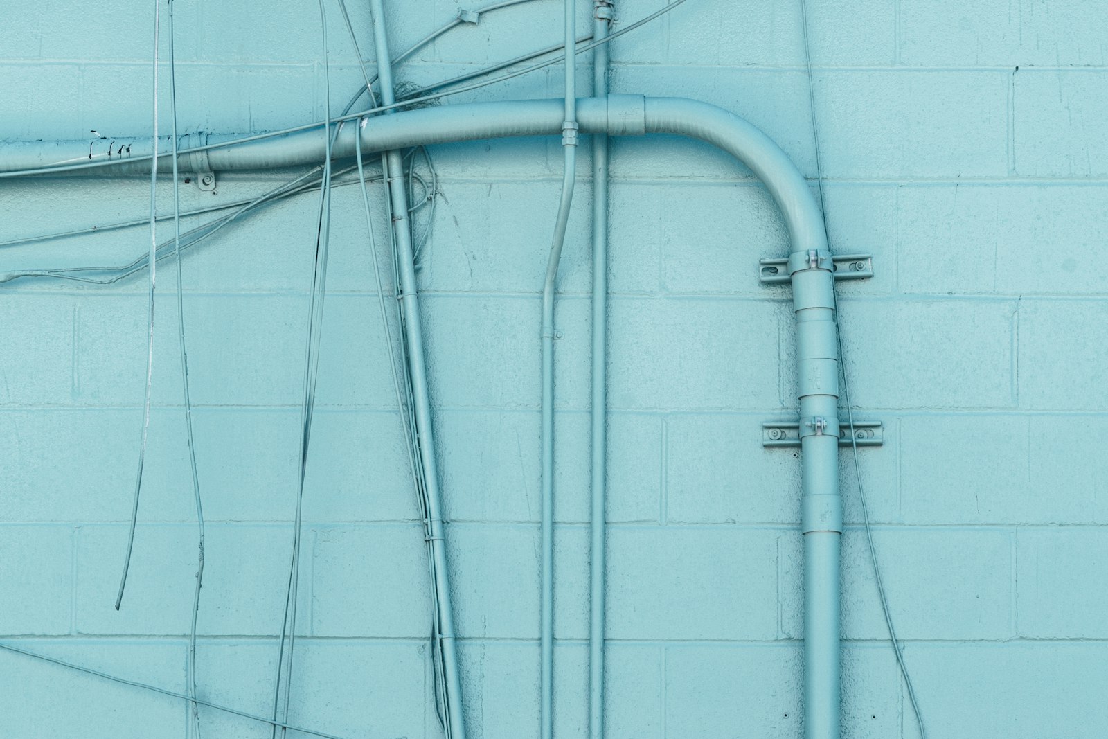 Conduits on a teal wall